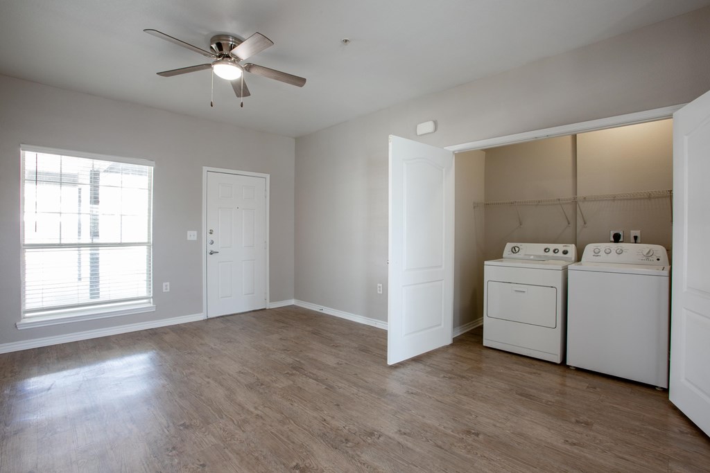 A room with a ceiling fan and a washer and dryer.