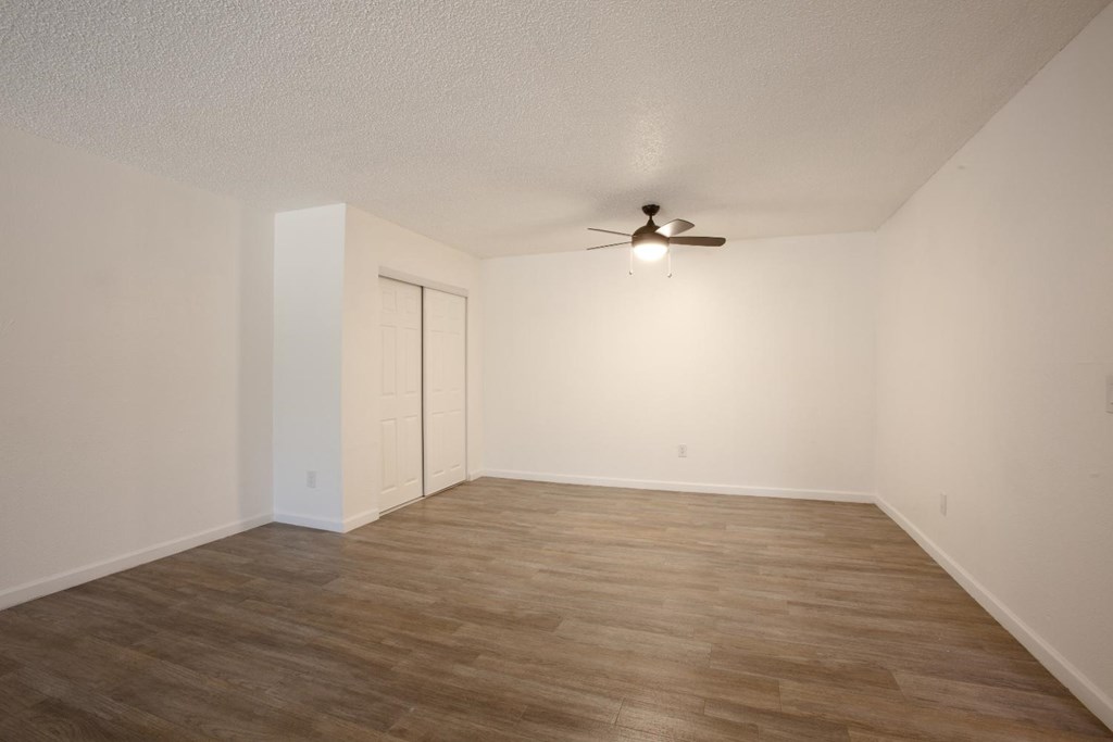 A room with a ceiling fan and a sliding door.