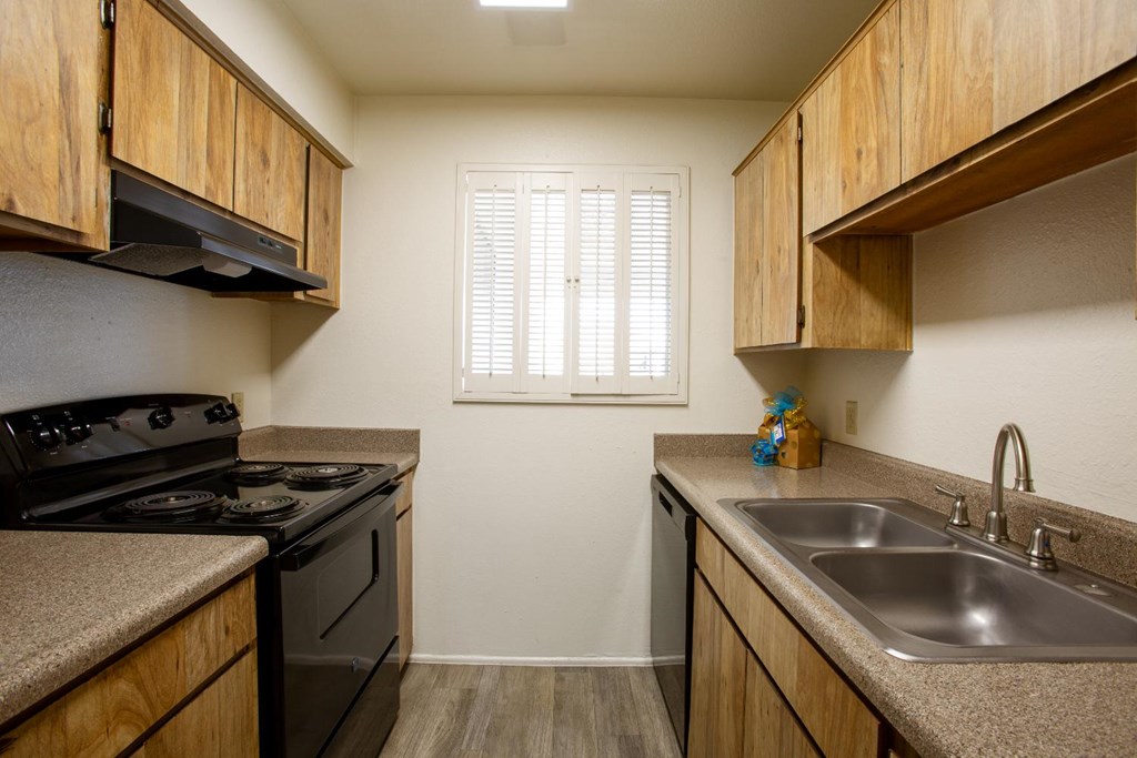 A kitchen with wooden cabinets and a black stove top oven.