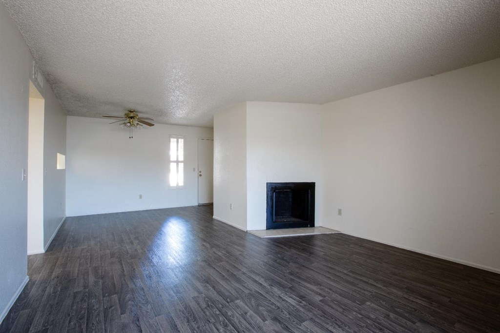 A room with a fireplace and wood flooring.