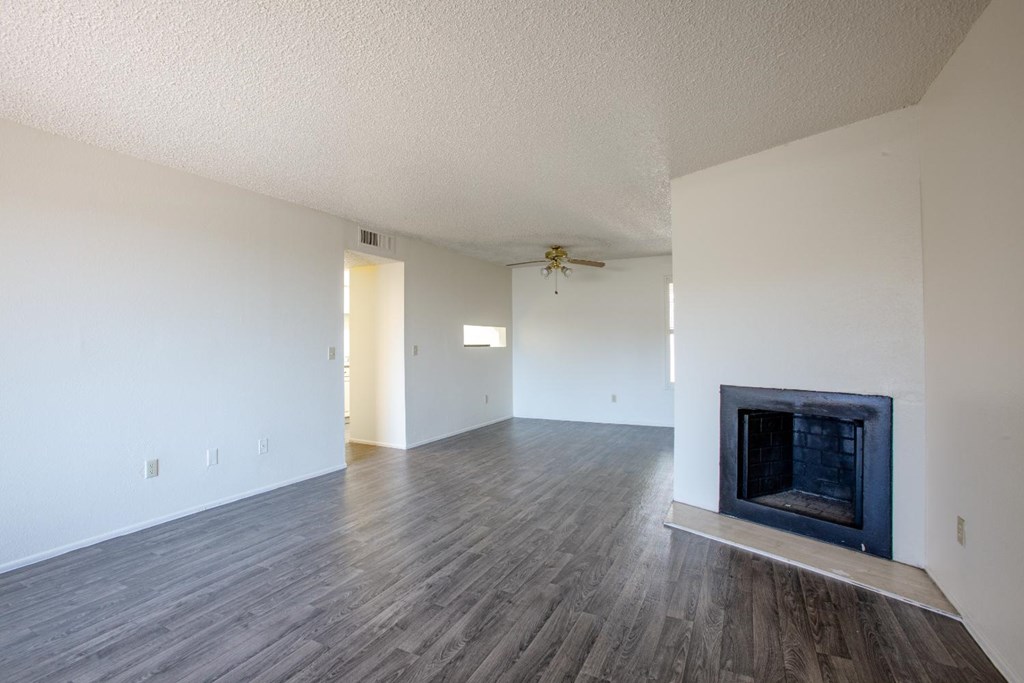 A room with a fireplace and wood flooring.