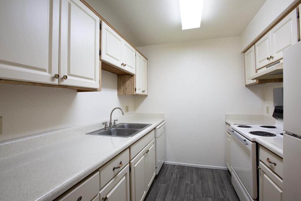 A kitchen with white cabinets and appliances.
