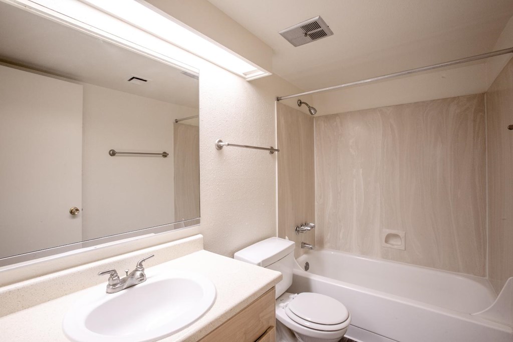 A white bathroom with a sink, toilet, and bathtub.