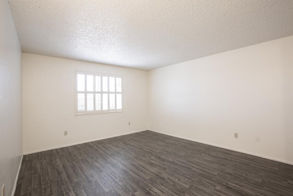 A room with a window and wooden flooring.