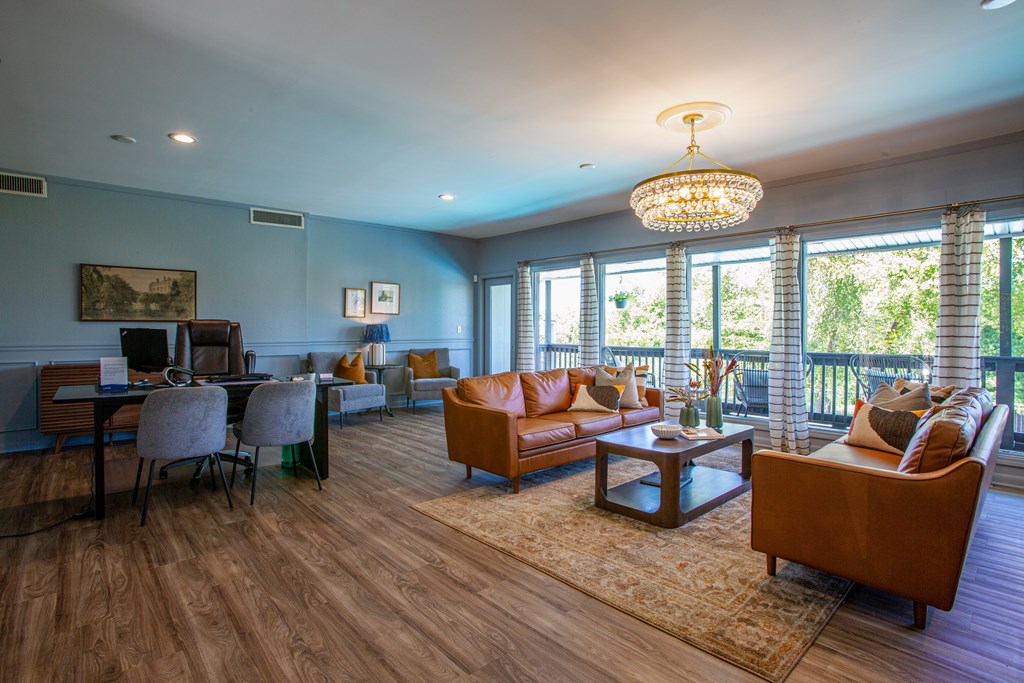 A living room with a large window and a balcony.