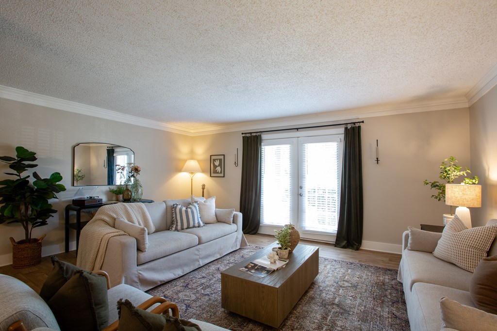 A living room with a couch, a coffee table, and a potted plant.