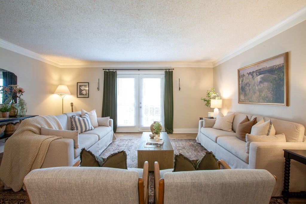 A living room with a grey sofa, a white armchair, and a wooden coffee table.