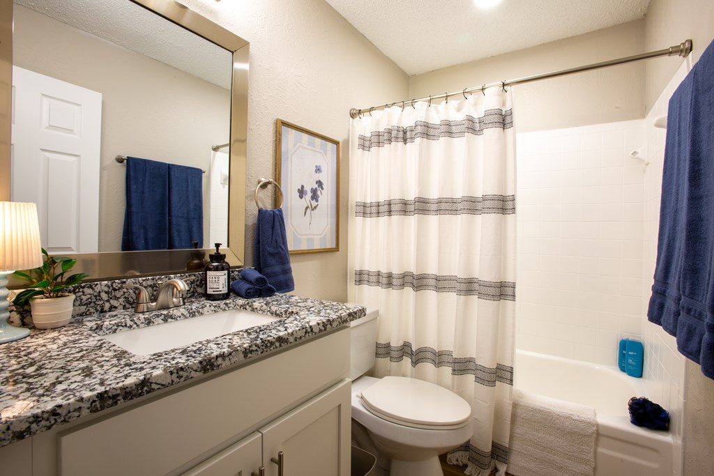 A bathroom with a toilet, sink, and shower.