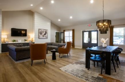 A modern living room with a dark wood floor and furniture.