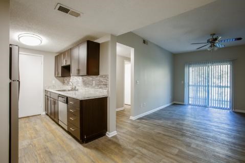 A kitchen with wooden floors and a ceiling fan.