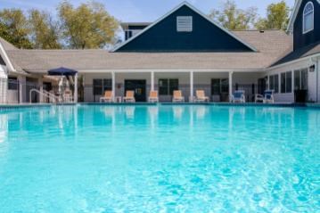A large swimming pool in front of a house.