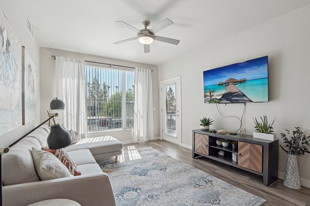 A living room with a large flat screen TV mounted on the wall.