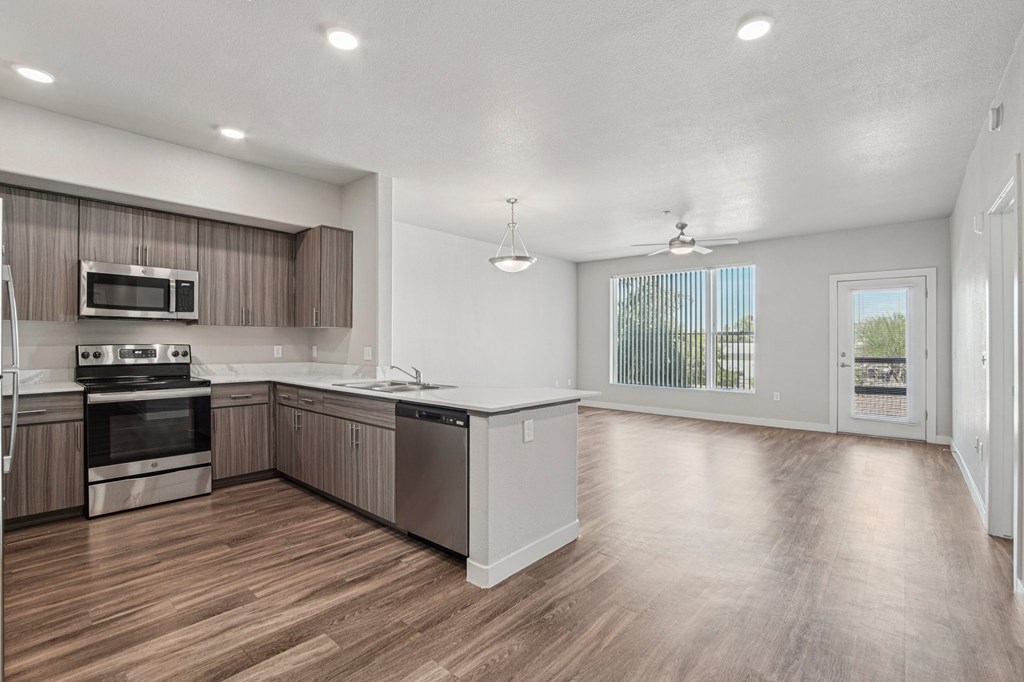 A spacious kitchen with wooden floors and modern appliances.