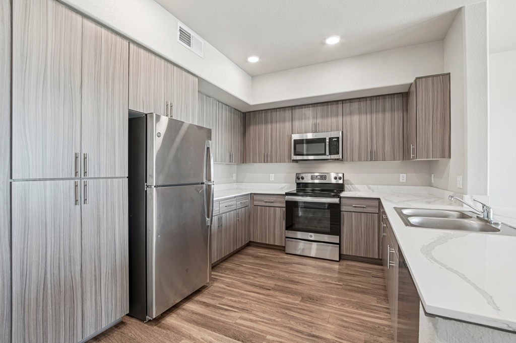 A modern kitchen with wooden cabinets and stainless steel appliances.