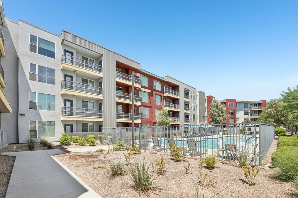 A modern apartment complex with a pool in the courtyard.
