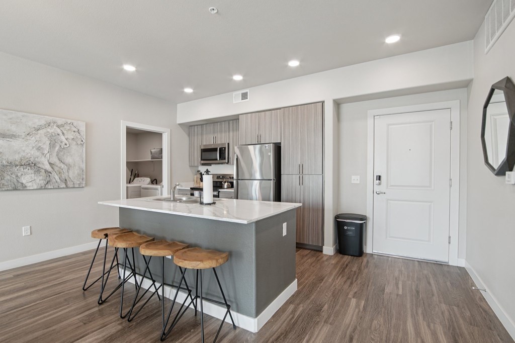 A kitchen with a bar stool and a counter.