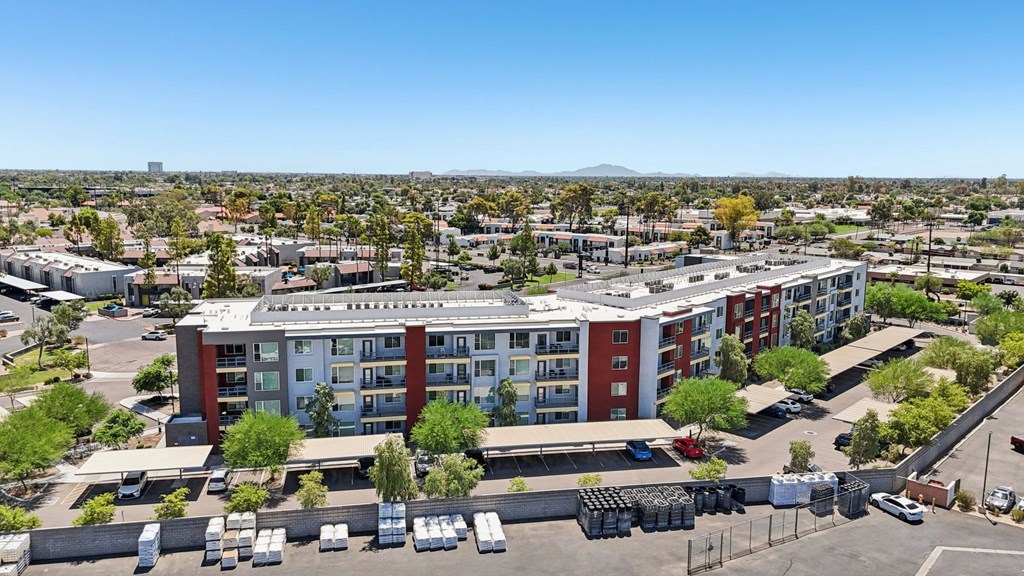 A large red and white building with a parking lot in front.