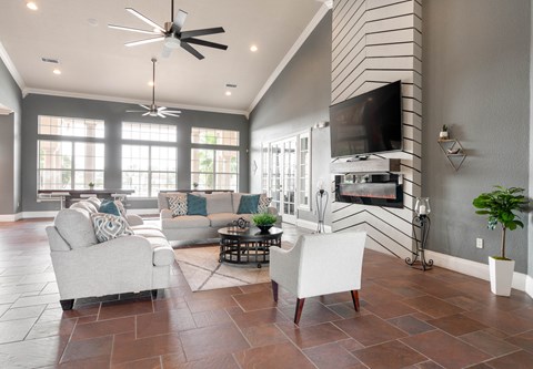A living room with a white couch, a black coffee table, and a ceiling fan.