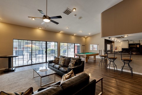 A living room with a pool table and a bar area.