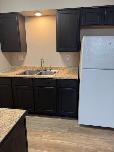 A kitchen with a white fridge and black cabinets.