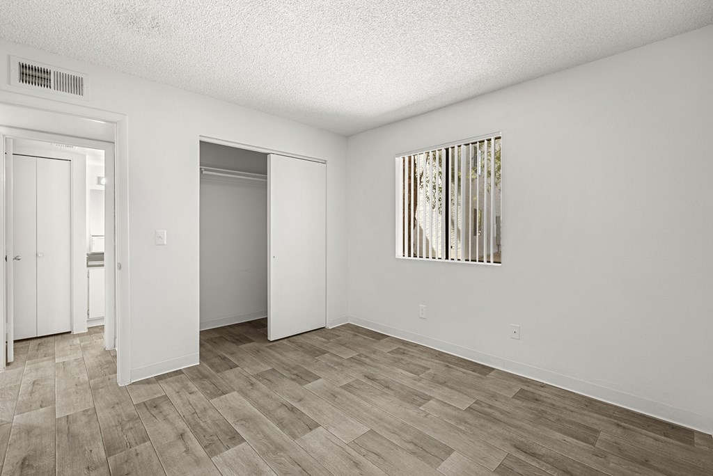 A room with a wooden floor and a painting on the wall.