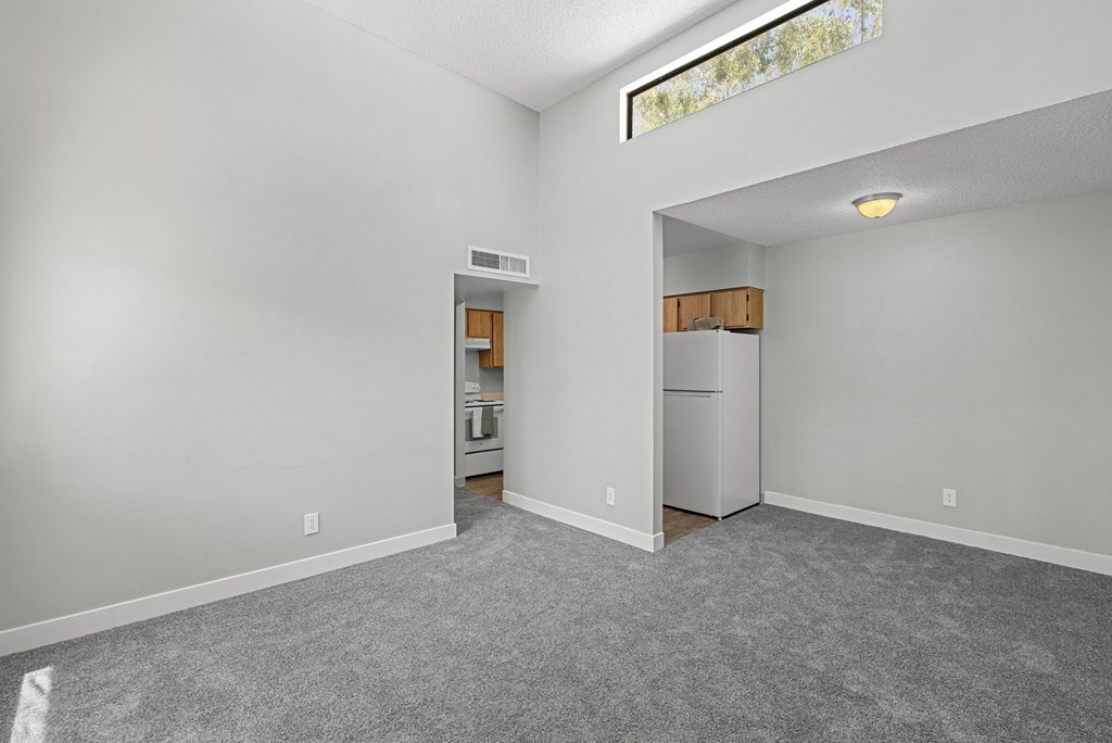 A room with a kitchenette in the other room.