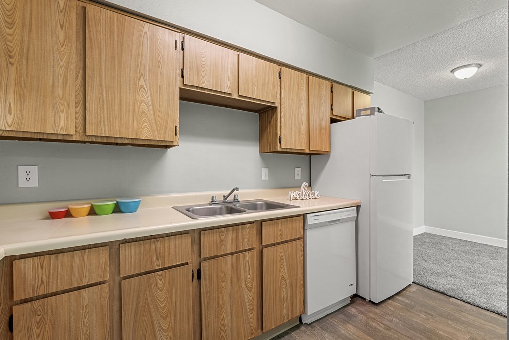 A kitchen with wooden cabinets and a white refrigerator.