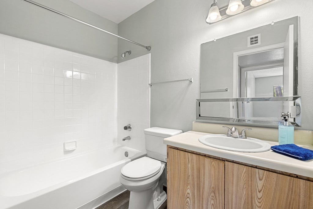 A white bathroom with a toilet, sink, and bathtub.