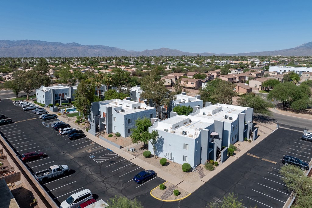 A parking lot with several cars and a building in the background.