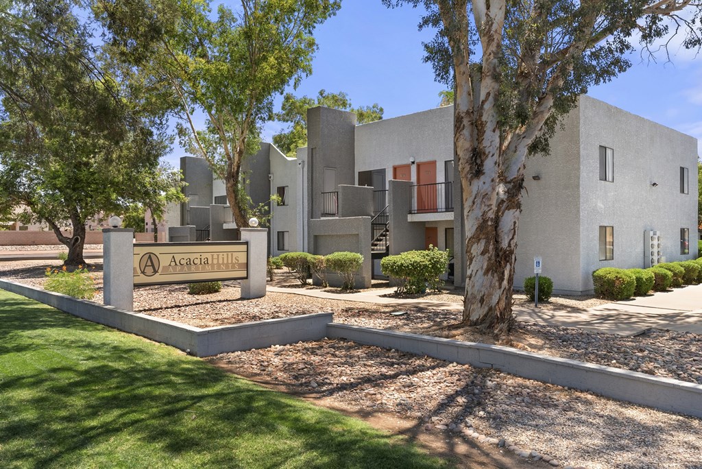 A modern building with a sign that reads "Acacia Hill" in front of it.