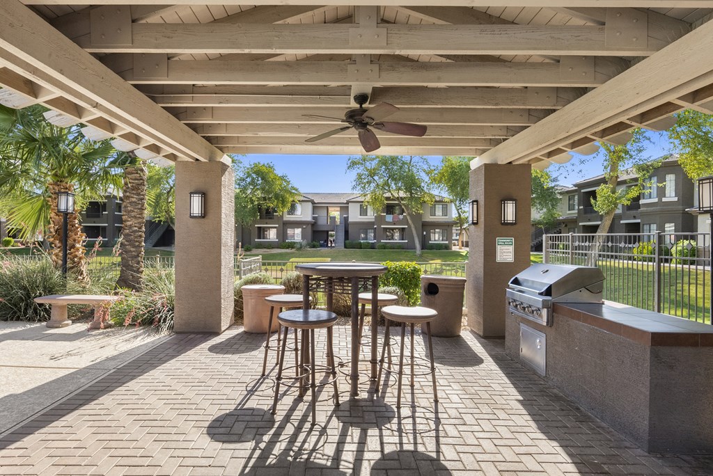 A patio with a table and chairs under a roof.