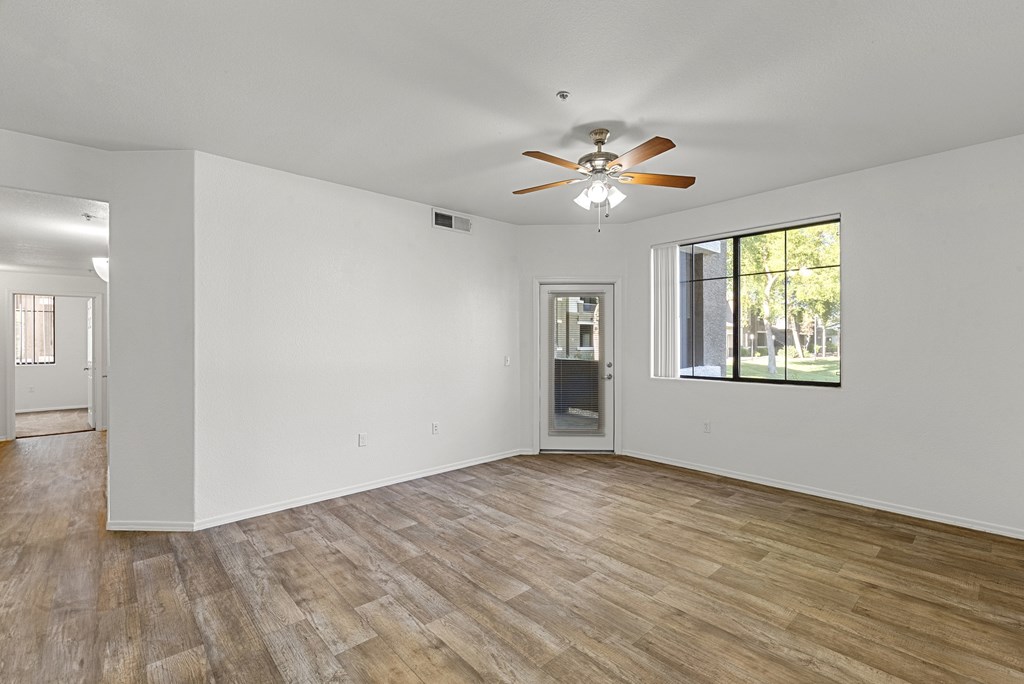A room with a ceiling fan and wooden flooring.