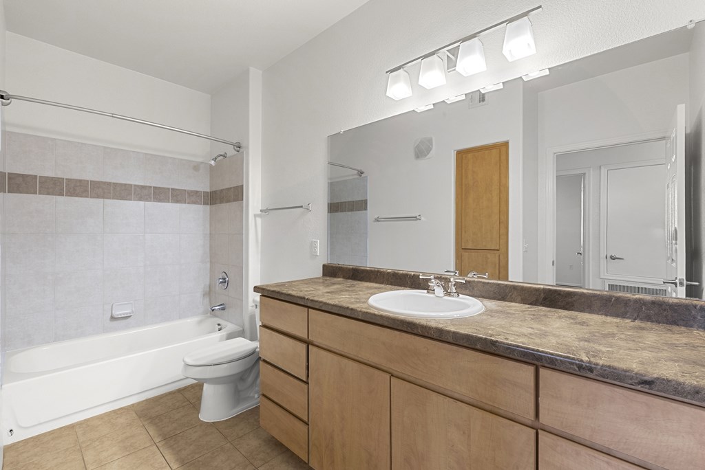 A bathroom with a sink, toilet, and bathtub.