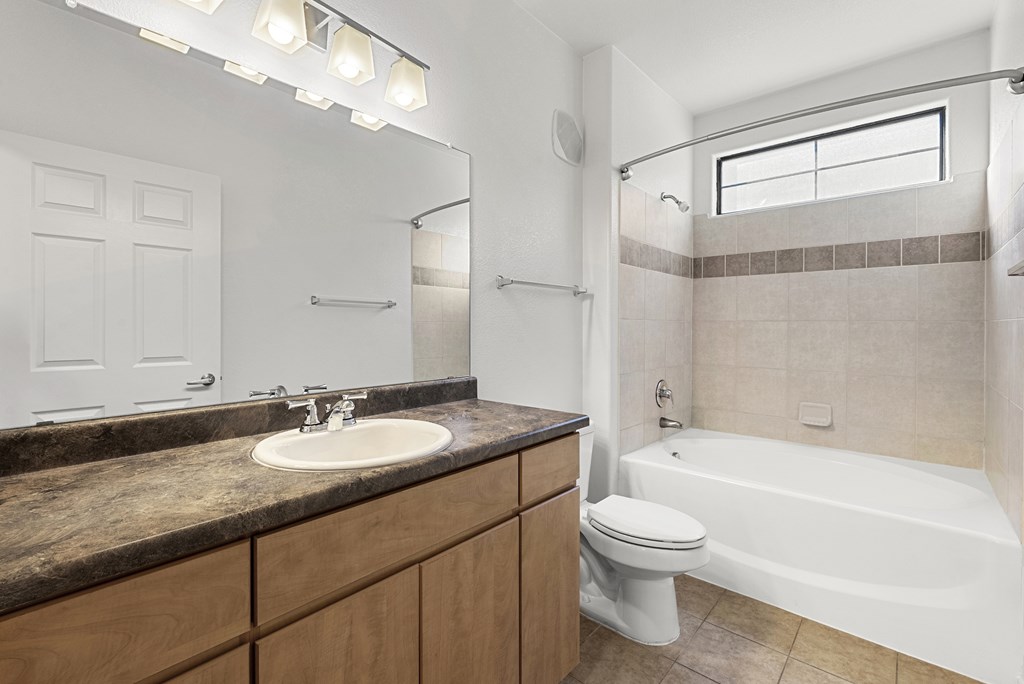 A bathroom with a sink, toilet, and bathtub.