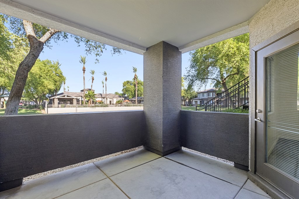 A patio with a view of a tree and houses.