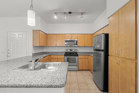 A kitchen with wooden cabinets and a granite countertop.