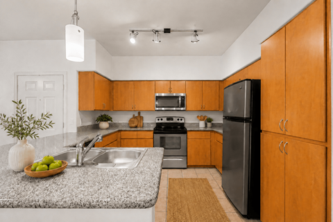 A kitchen with wooden cabinets and a black refrigerator.