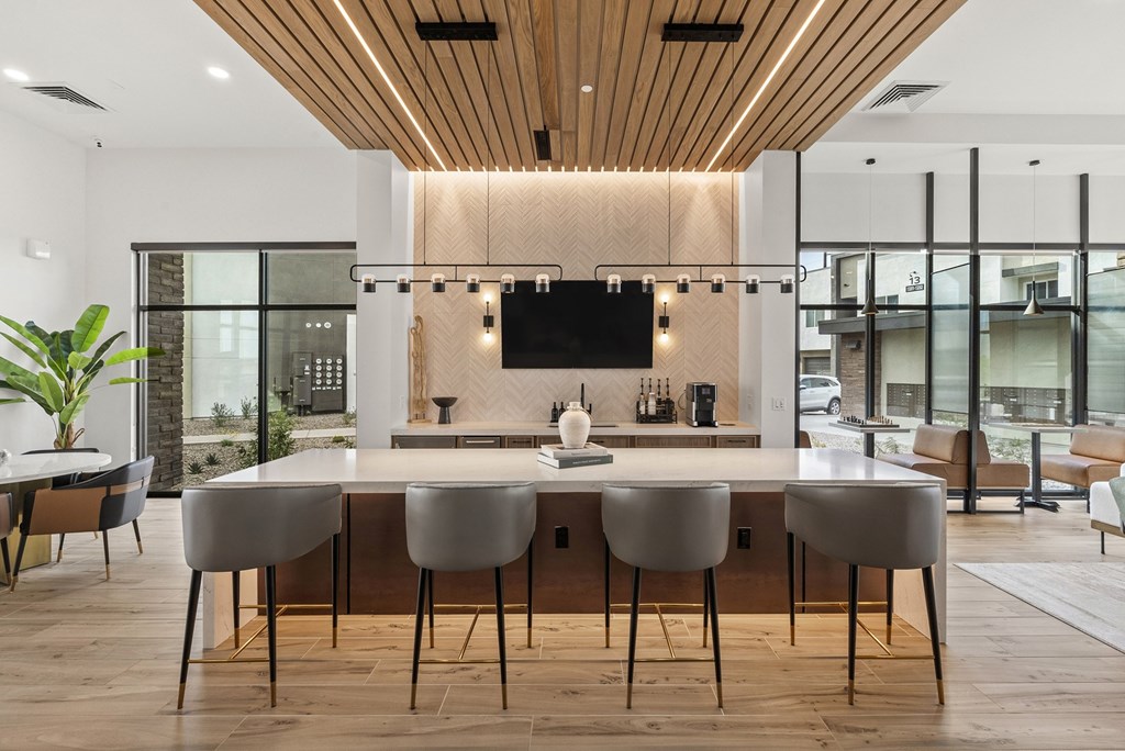 A modern kitchen with a long island and chairs.