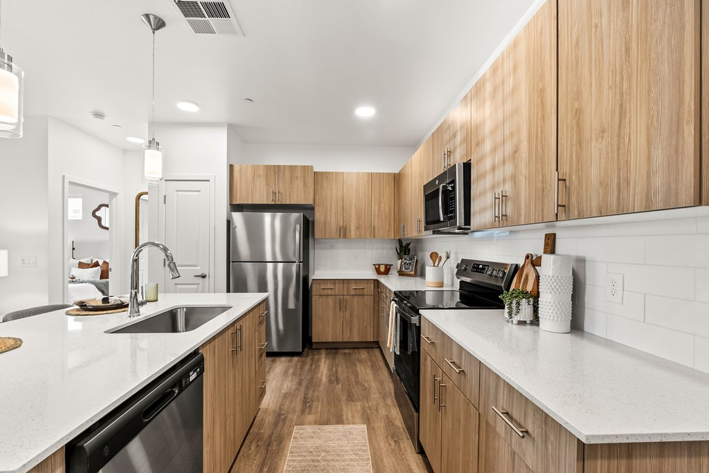 A modern kitchen with wooden cabinets and stainless steel appliances.