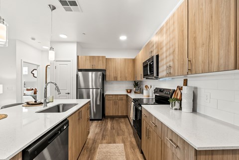 A modern kitchen with wooden cabinets and stainless steel appliances.