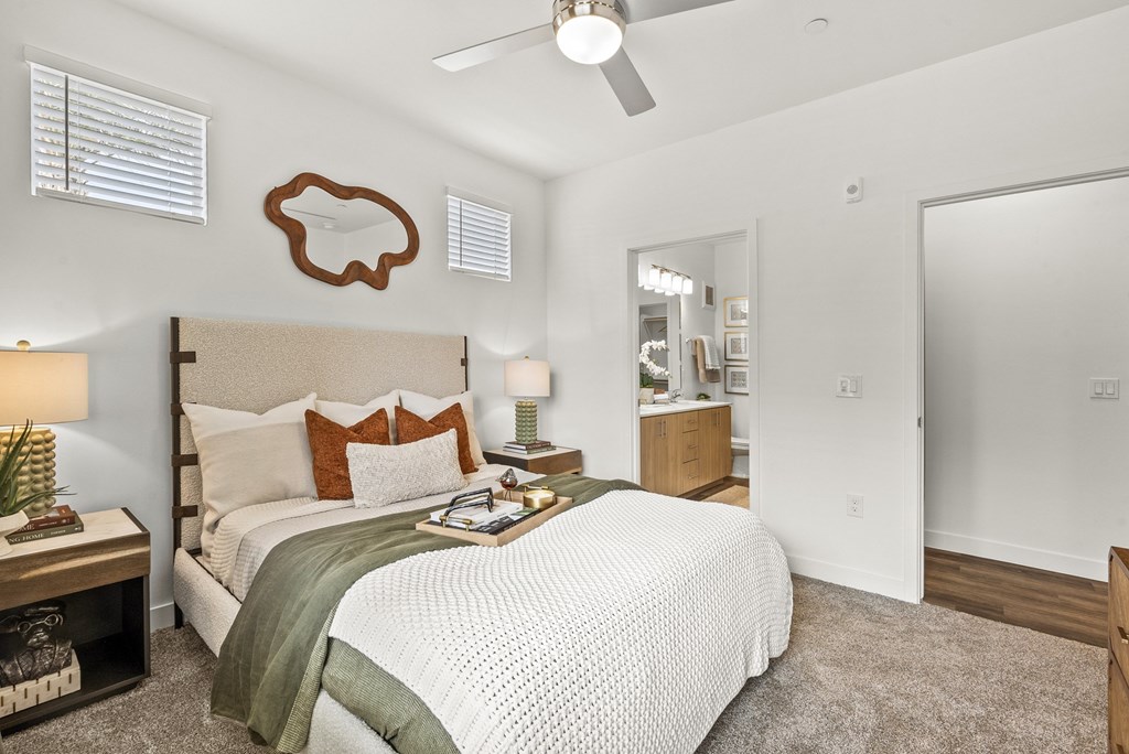 A bedroom with a bed, nightstand, and a ceiling fan.