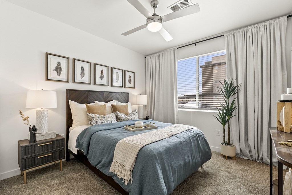 A bedroom with a bed, nightstand, and a ceiling fan.