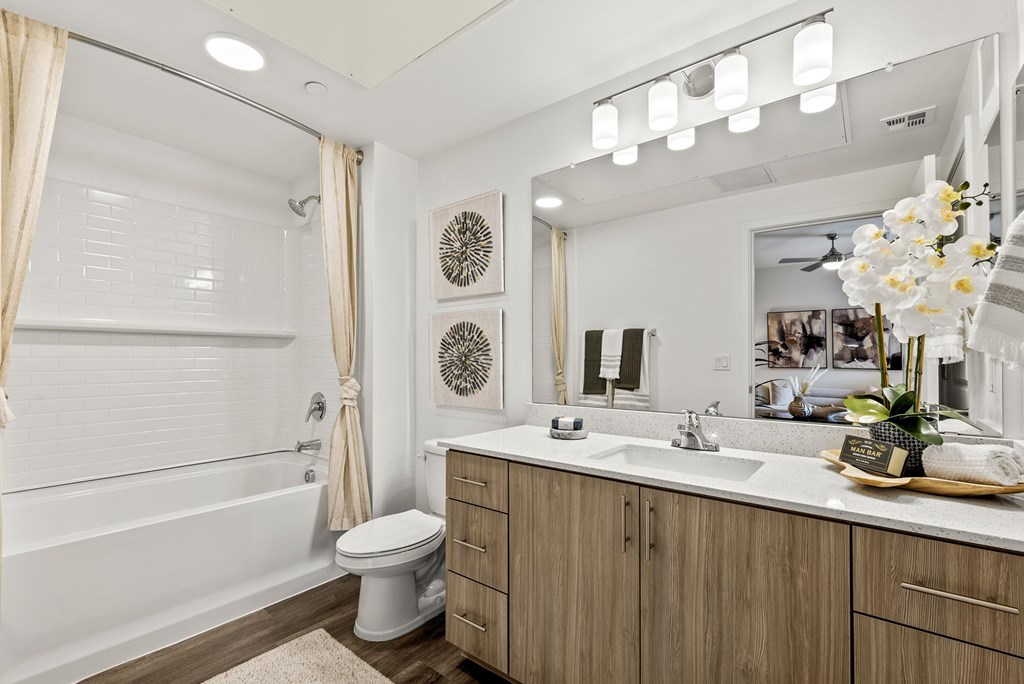 A bathroom with a white tub, sink, and toilet.