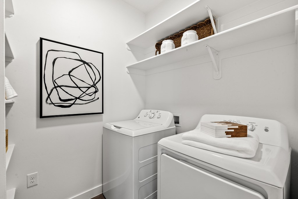 A laundry room with a washer and dryer and a picture on the wall.
