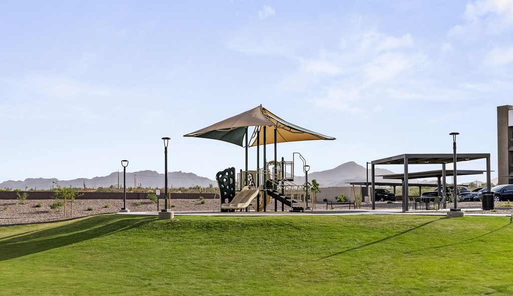 A playground with a slide and a canopy is in the foreground.