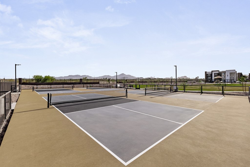 A tennis court with a net and two courtside buildings.