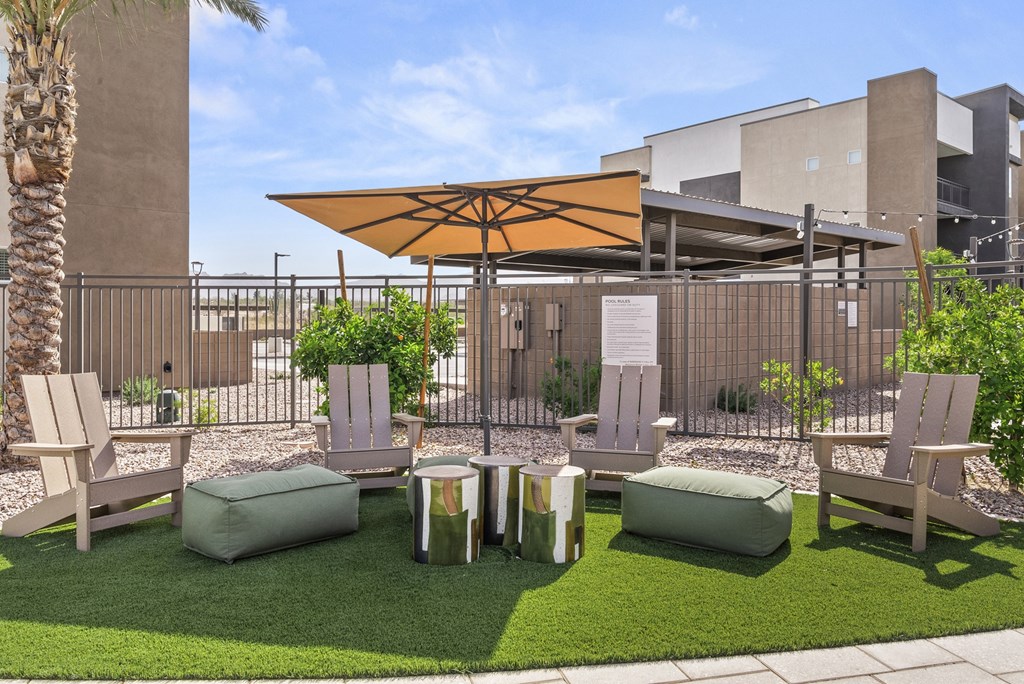 A patio area with a table, chairs, and a parasol.