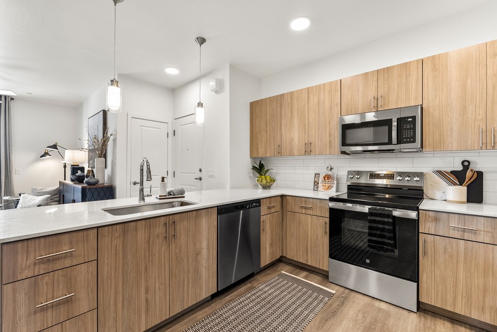 A modern kitchen with wooden cabinets and stainless steel appliances.