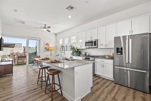 A modern kitchen with white cabinets and stainless steel appliances.