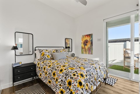 A bedroom with a bed, nightstand, and a painting on the wall.